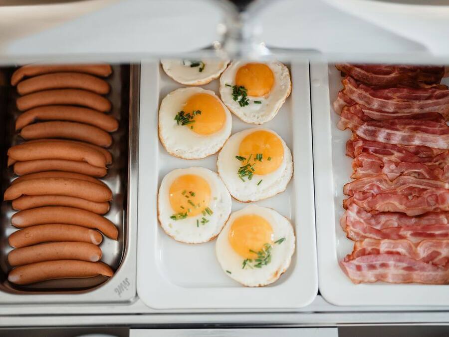 Un refrigerador con salchichas, huevos fritos y tocino.