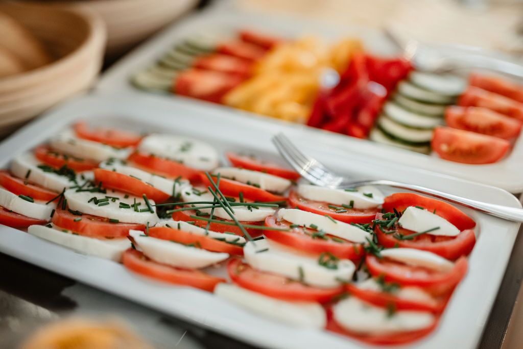 A plate of Caprese salad with tomatoes, mozzarella, and basil.