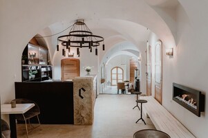 Un interior moderno con un pasillo en arco, una recepción, un área de estar y una chimenea.