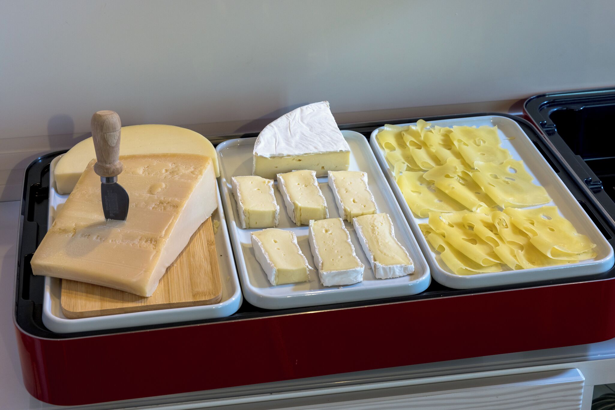 A cheese and pasta display with a cheese knife.