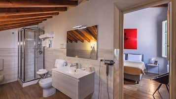 A modern bathroom with a glass shower enclosure, a white sink, and a large mirror.
