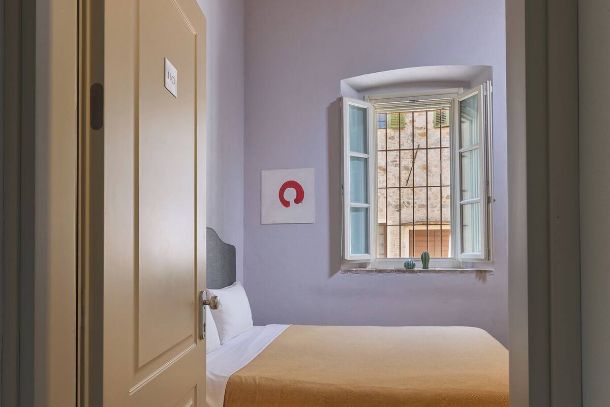 Une chambre à coucher avec un lit, une fenêtre et une porte.