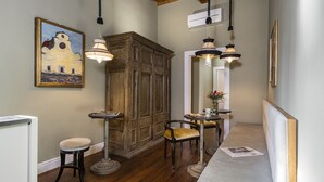 A hallway with wooden flooring, a wooden cabinet, a bench, and pendant lights. - Parione Uno (Florence)