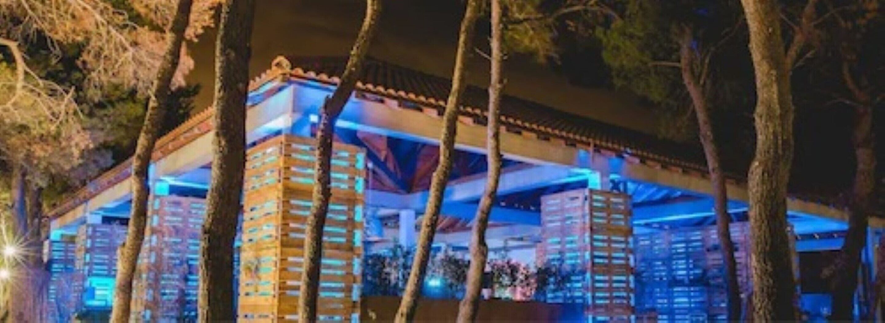 A multi-story hotel with a modern design, featuring a flat roof and large windows.