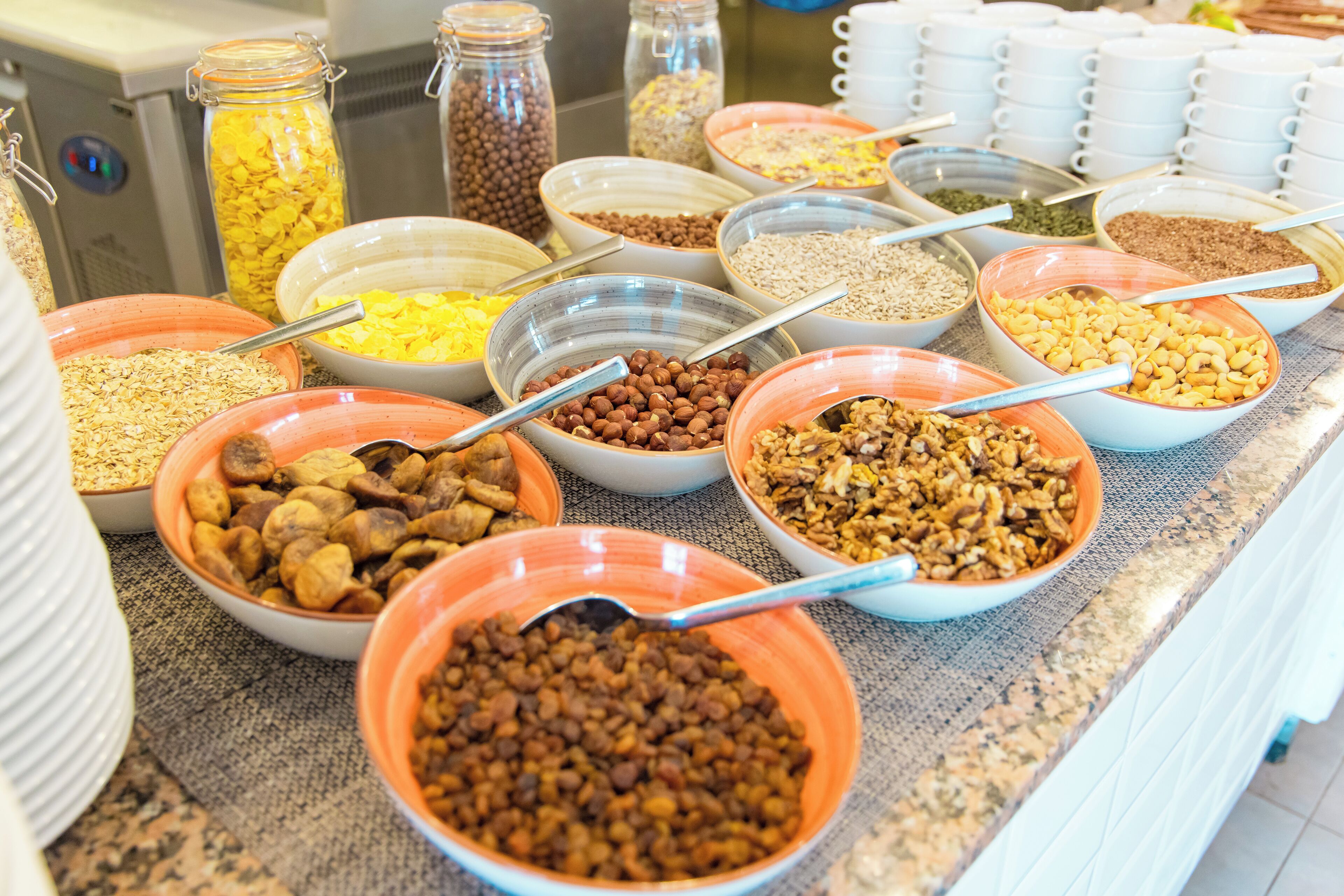Un bufé con diferentes alimentos en cuencos y frascos.