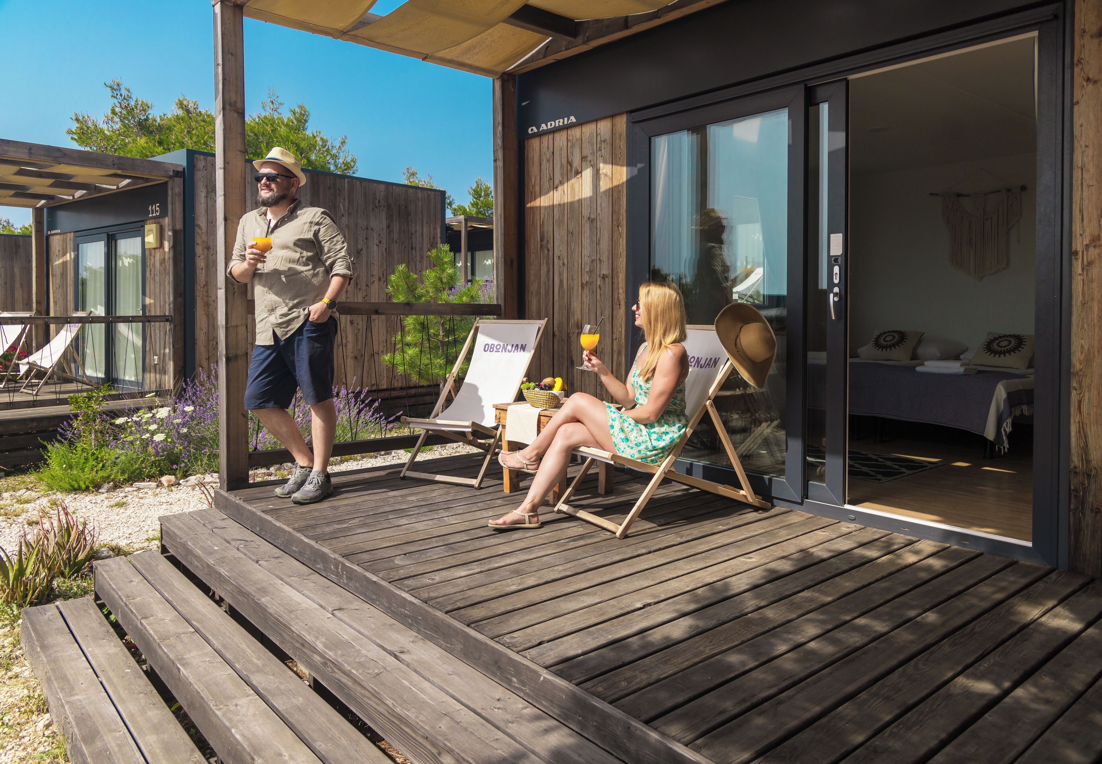 A wooden deck with a glass door leading to a room.