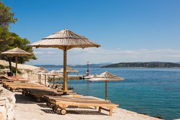 Sillas reclinables de playa, sombrillas, toallas de playa