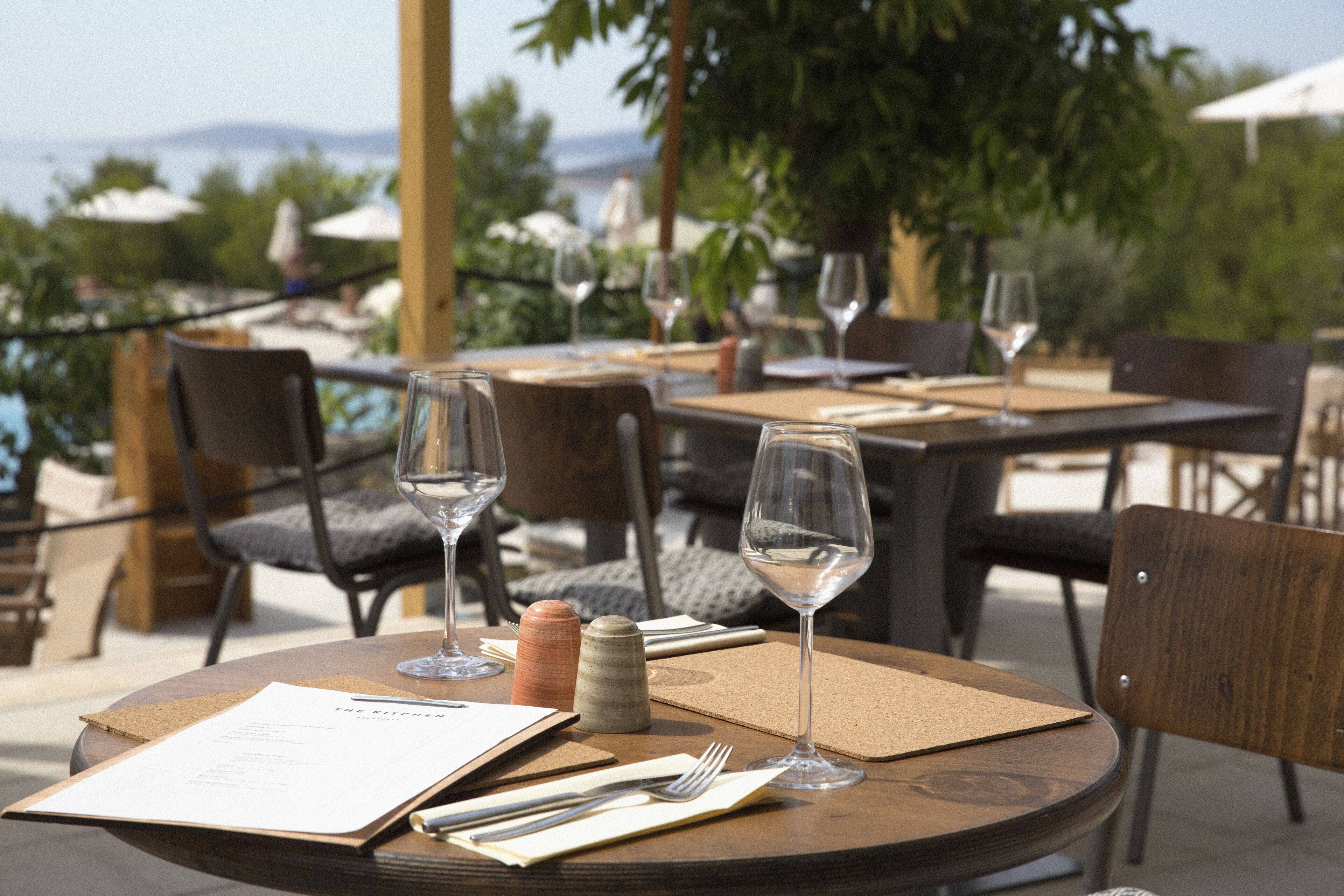 A table set for dining with a menu, wine glasses, and a salt shaker.