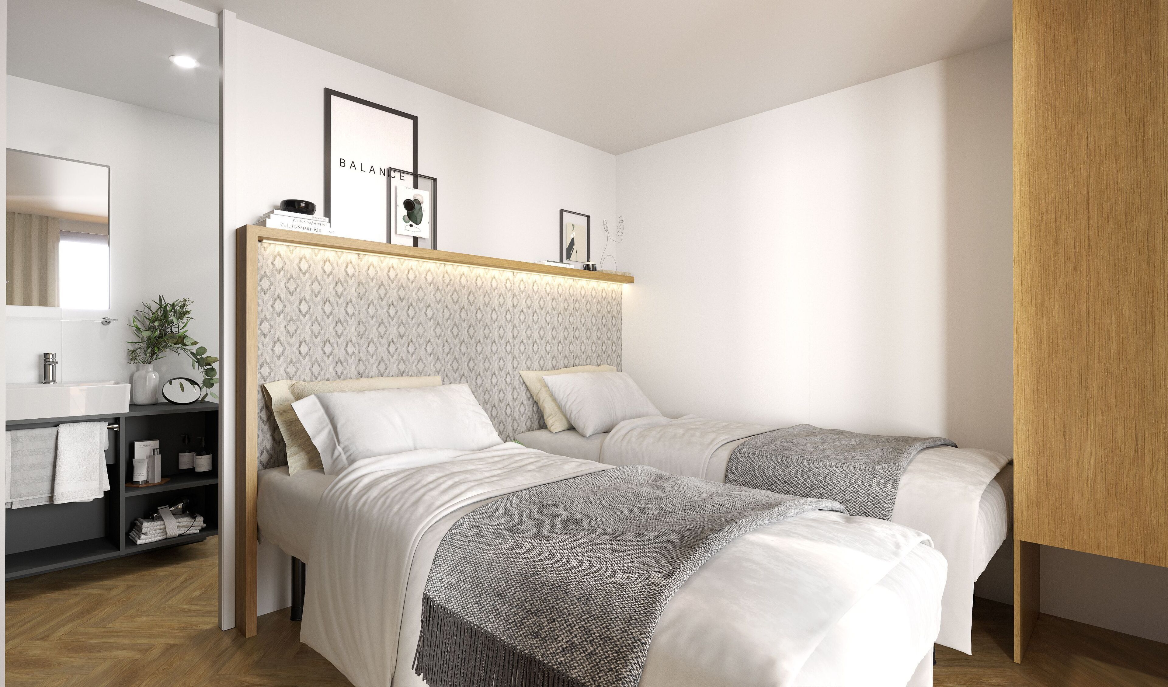 A modern bedroom with two beds, a bedside table with a lamp, a mirror, and a framed picture on the wall.