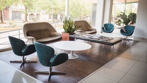 Un interior moderno con un sofá, dos sillones, una mesa de centro y una planta en maceta.