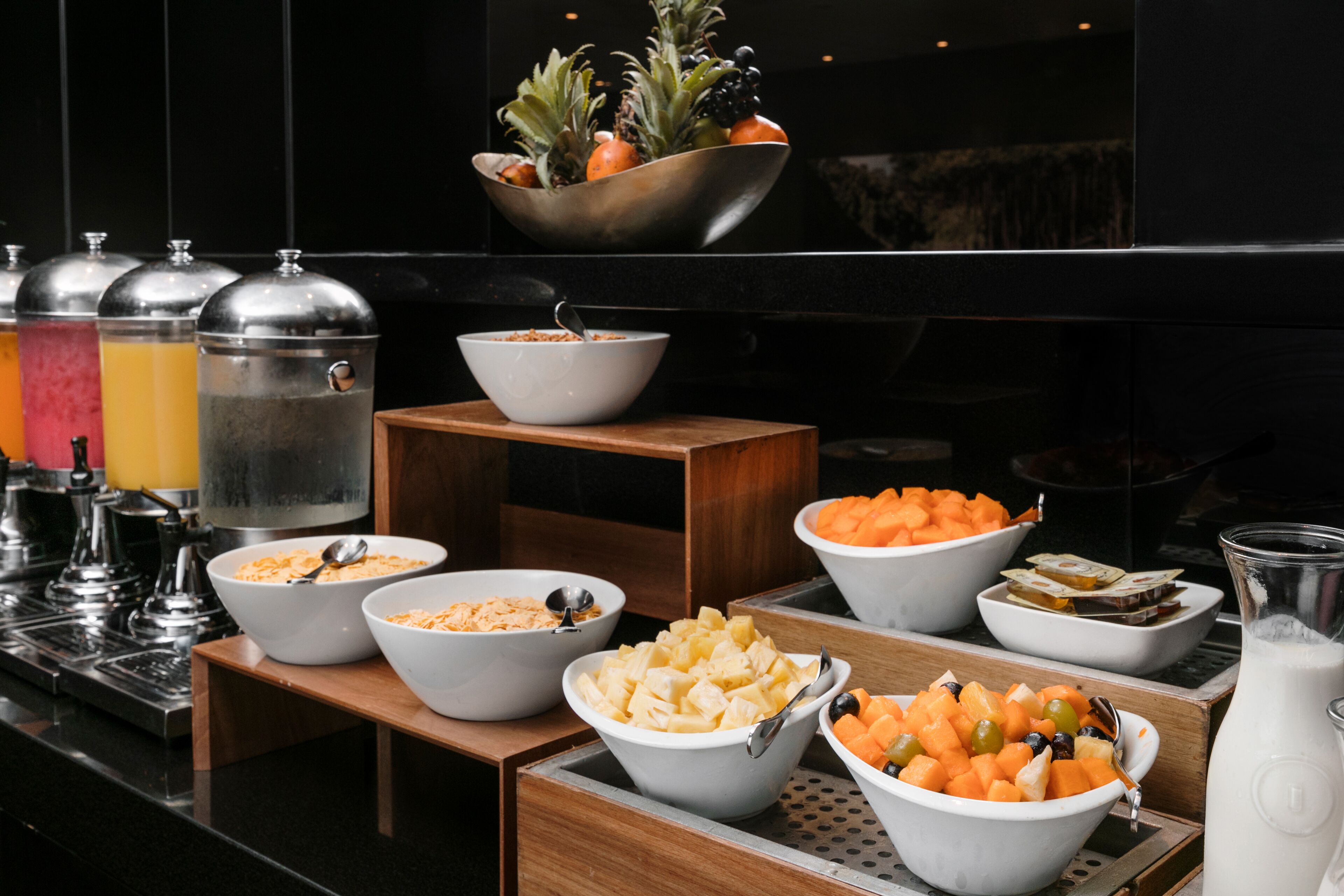 A breakfast buffet with various food options and a fruit bowl.