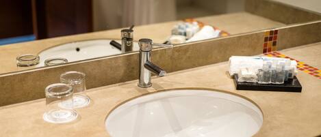 A bathroom sink with a mirror, a faucet, and a soap dispenser.