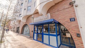 A modern hotel with a blue and white facade, a prominent 'motel' sign, and a brick wall. - Montempô Apparthôtel Evry (Évry-Courcouronnes)