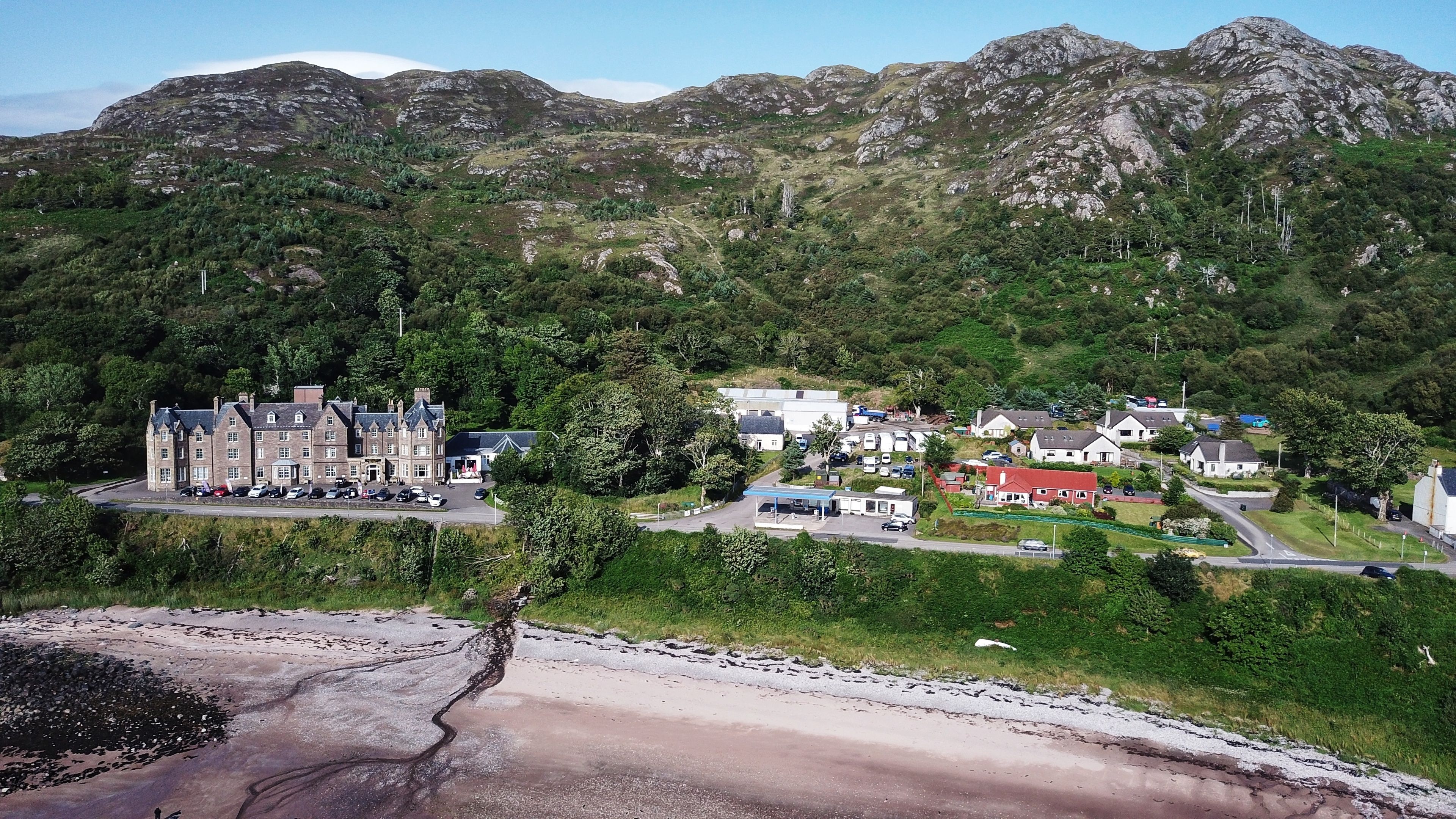 A coastal town with a prominent castle-like building, a small industrial area, and residential houses.