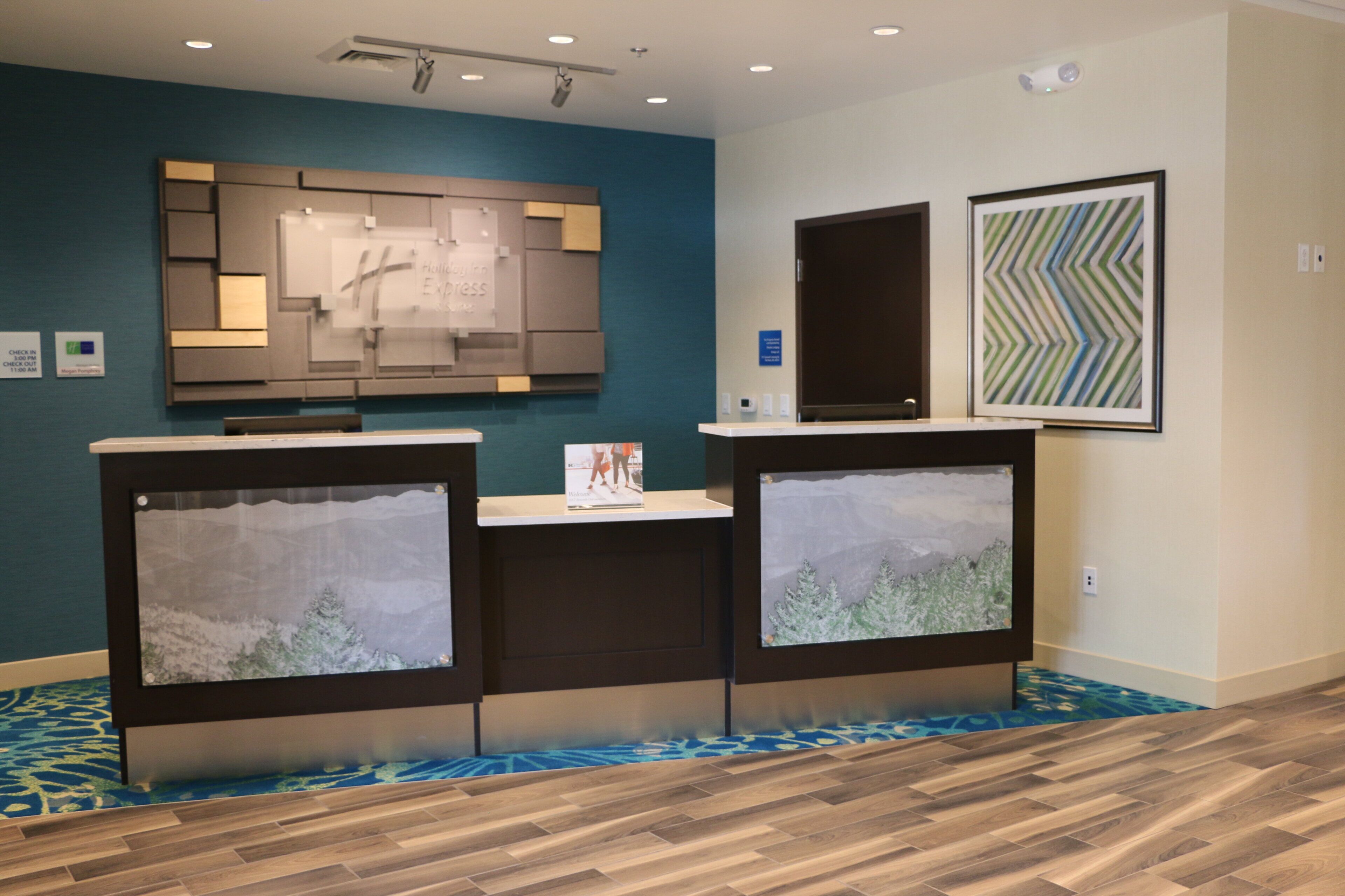 A reception area with a blue wall, a reception desk, and framed artwork.
