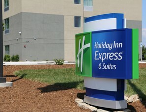 A Holiday Inn Express & Suites sign with a modern design, located in front of a building with a grey facade and a clear sky. - Holiday Inn Express & Suites Hendersonville SE - Flat Rock by IHG (Flat Rock)