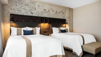 Une chambre d’hôtel avec deux lits, une grande carte accrochée au mur et un banc.