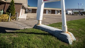 Une enseigne de motel portant le nom « Colonial » et indiquant les équipements disponibles, notamment le Wi-Fi, la télévision par câble, un réfrigérateur et la climatisation.