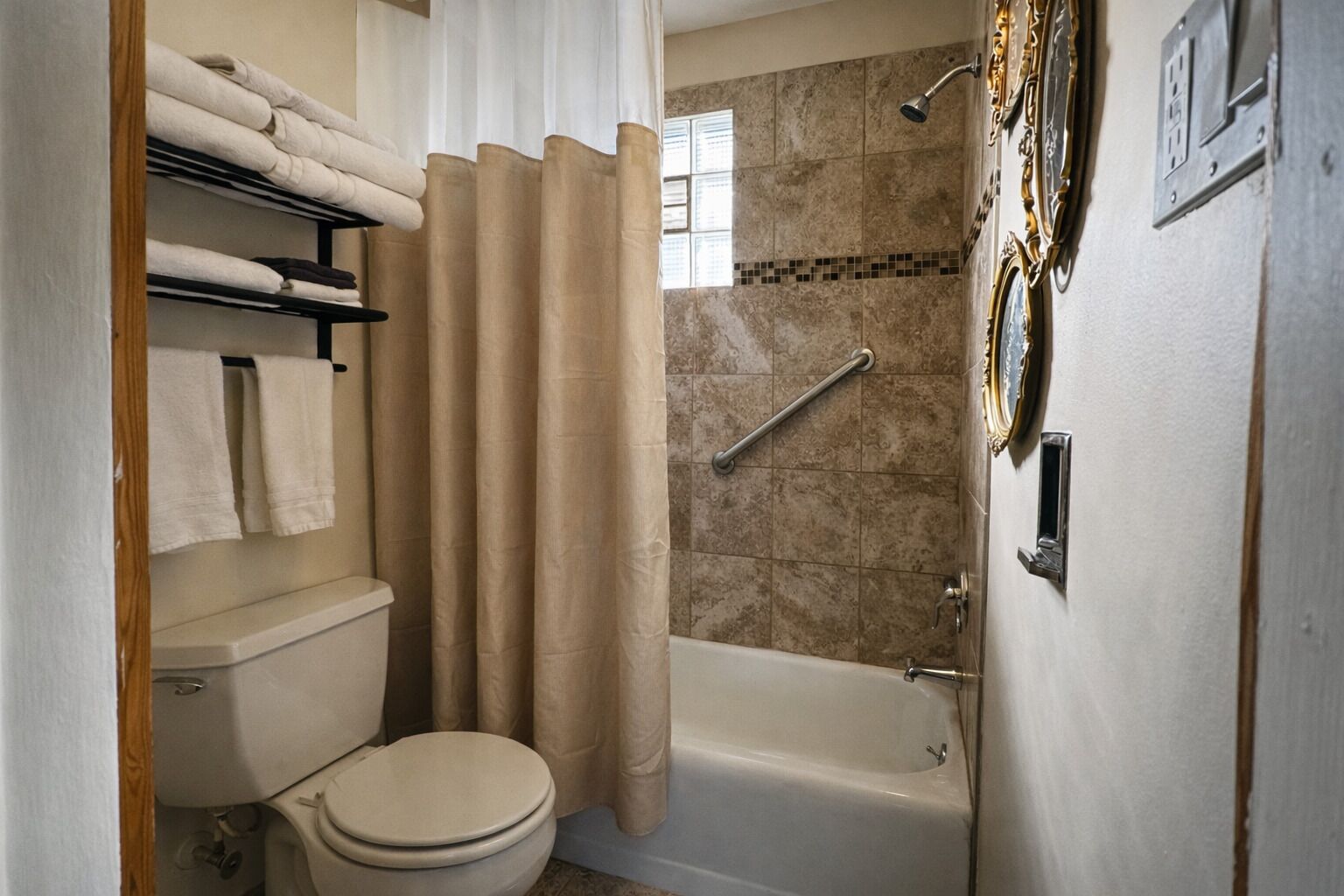 Un baño con inodoro, bañera y cortina de ducha.