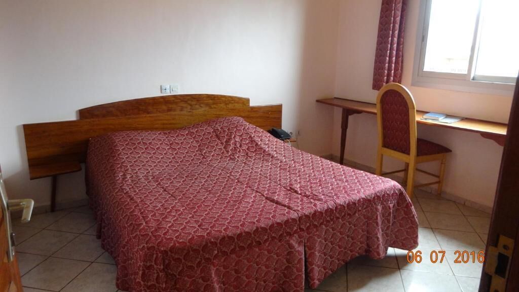 Un dormitorio con cama, escritorio y silla.