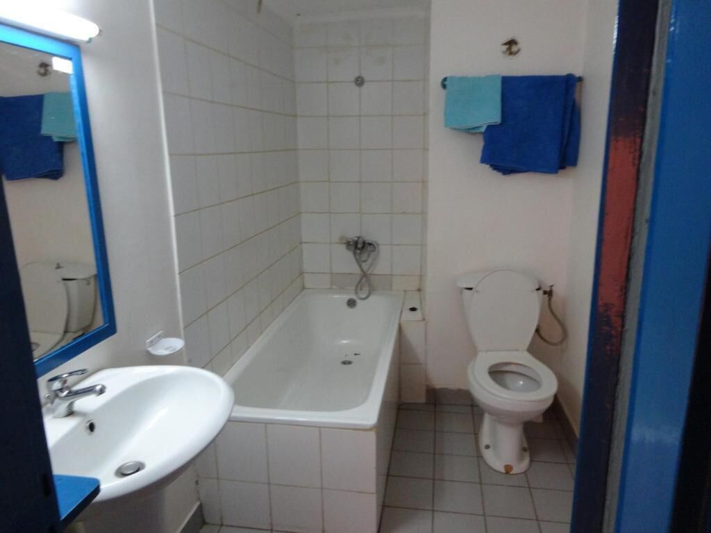 A bathroom with a white sink, a bathtub, and a toilet.