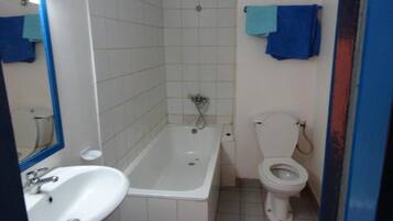 A bathroom with a white sink, a bathtub, and a toilet.