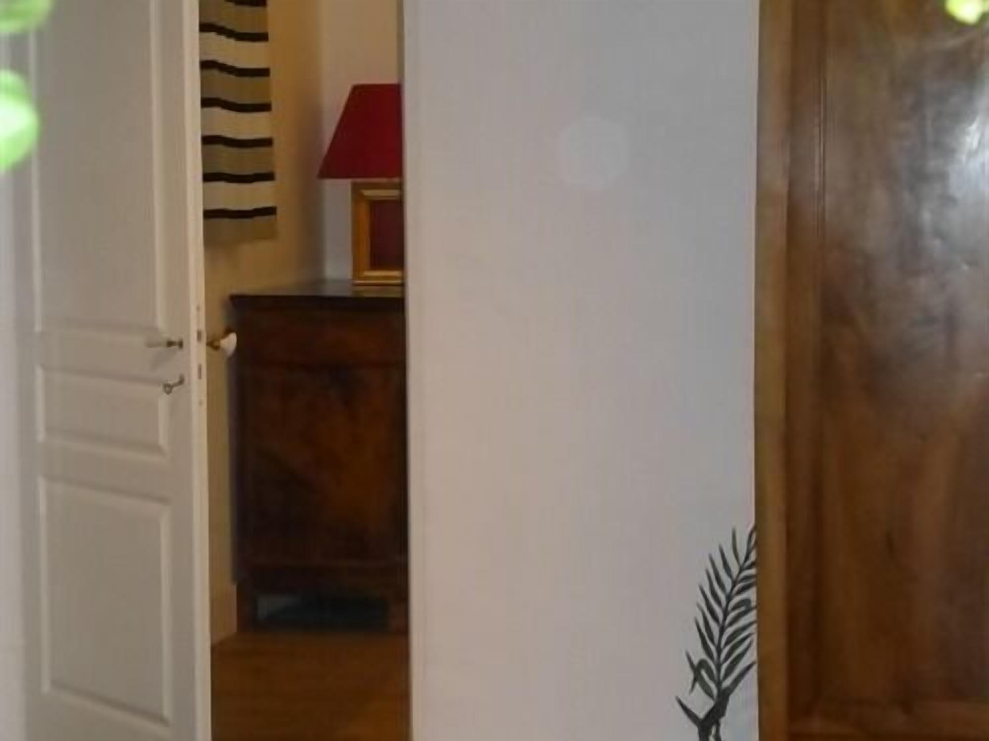 Una porta in legno con una decorazione a foglia, un telaio bianco e un pavimento in legno.