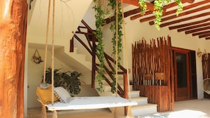 Una escalera de madera con una silla colgante y plantas suspendidas.