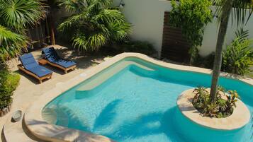 Alberca al aire libre y camastros