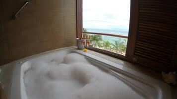 Una bañera con vista al océano a través de una ventana.