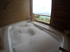 Una bañera con vista al océano a través de una ventana.