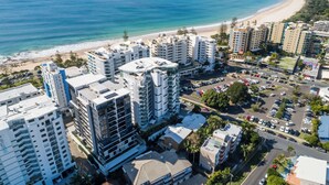 A coastal cityscape with high-rise buildings, a beach, and a clear view of the ocean. - First Light Mooloolaba, an Ascend Collection Hotel (Mooloolaba)