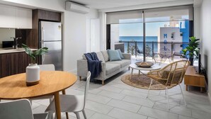 A modern apartment with a kitchen, dining area, and a balcony with a view of the sea. - First Light Mooloolaba, an Ascend Collection Hotel (Mooloolaba)