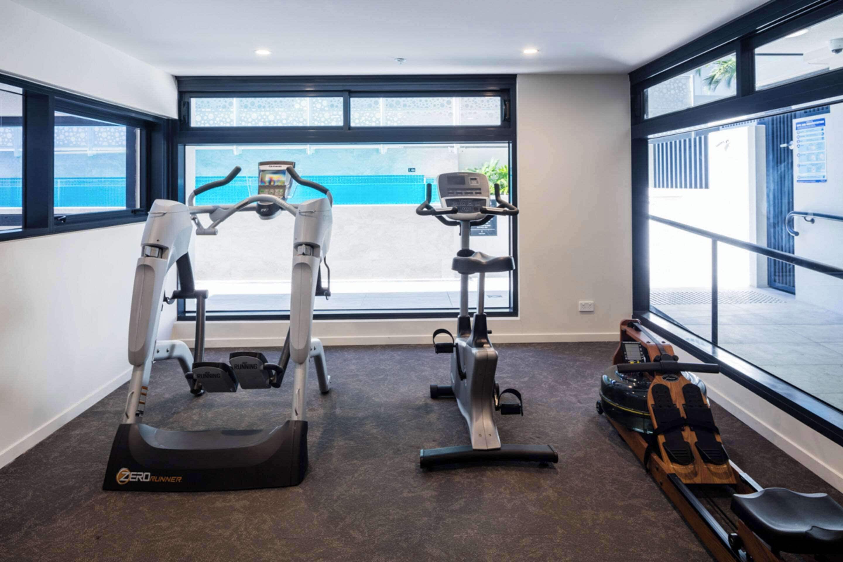 Una palestra con tapis roulant, una cyclette e un vogatore.