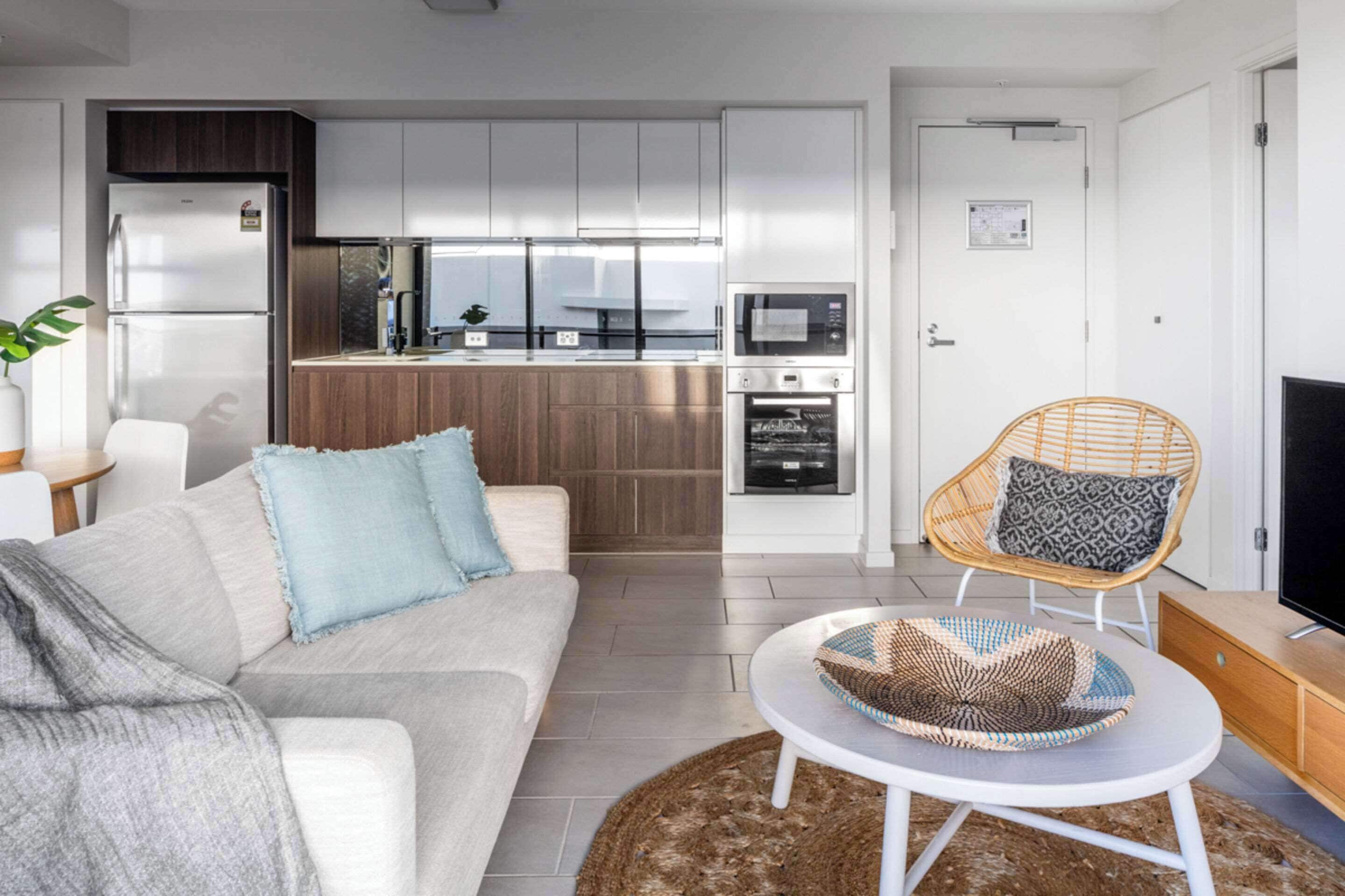A modern living room with a sofa, a coffee table, and a television.