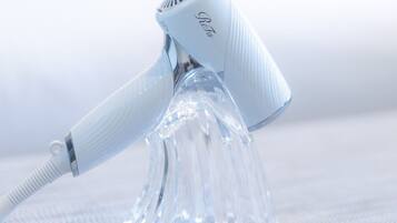 A hair dryer with a clear, ribbed handle and a transparent base.