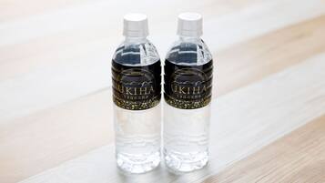 Two clear water bottles with labels on a wooden surface.