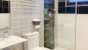 A modern bathroom with a toilet, sink, and glass shower enclosure. - The Awesome Manor (Ji'an)