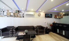 A modern living room with a sofa set, a coffee table, a TV, and a fireplace.