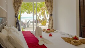 Una habitación de hotel con una cama, un edredón rojo y toallas dispuestas sobre la cama.