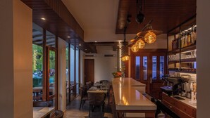 A modern bar area with a long counter, wooden accents, and pendant lighting. - Express Inn (Hulhumalé)