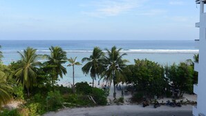 A beach view with palm trees, a clear sky, and a calm sea. - Express Inn (Hulhumalé)