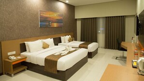 A hotel room with two beds, a desk, a telephone, and a painting on the wall. - Samara Resort (Batu)