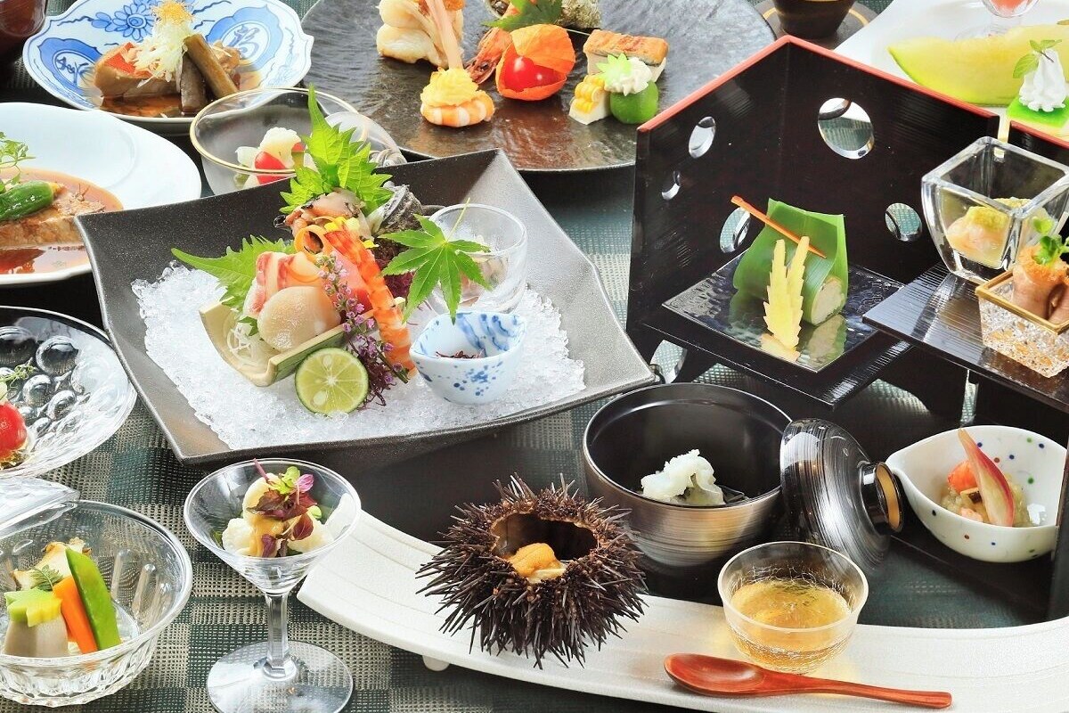 A variety of dishes on a table, including sushi, sashimi, and other seafood items.