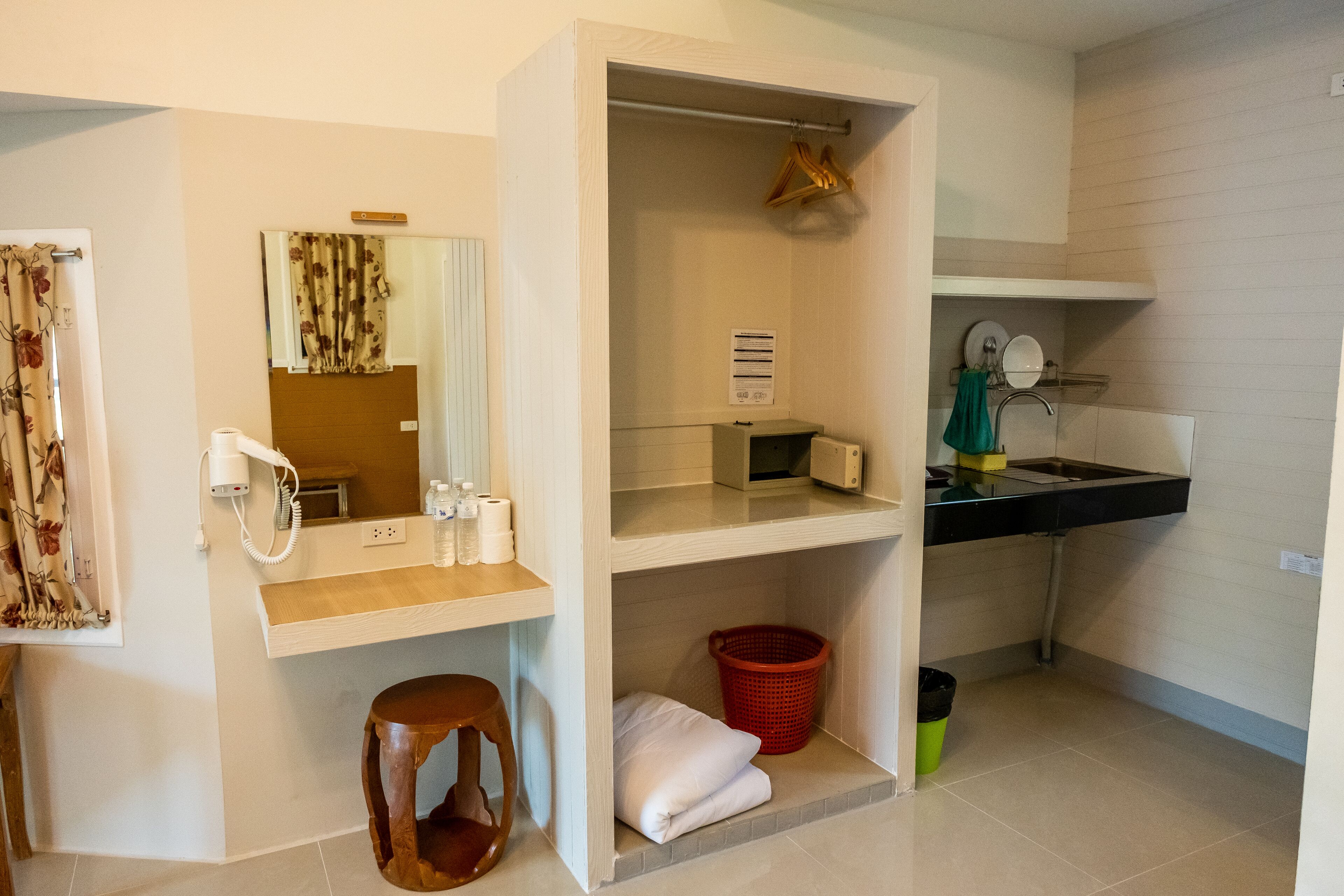 A bathroom with a mirror, towel rack, sink, and a red basket.