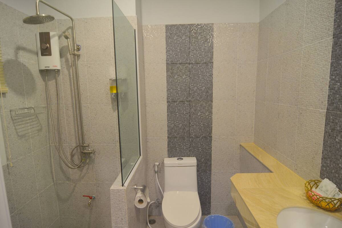 A bathroom with a shower, toilet, and sink.