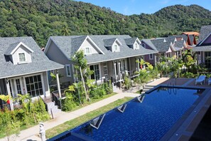 A hotel with multiple units featuring sloped roofs, a swimming pool, and lush greenery. - My Home Lantawadee Resort (Ko Lanta)