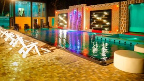 A swimming pool with a water feature and lounge chairs. - Hotel White House (Anuradhapura)