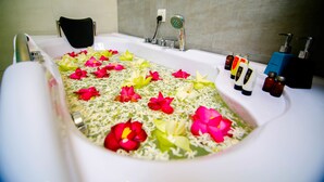 A bathtub filled with water and flower petals. - Hotel White House (Anuradhapura)