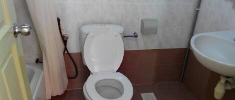 Un baño con inodoro, lavabo y cortina de ducha.